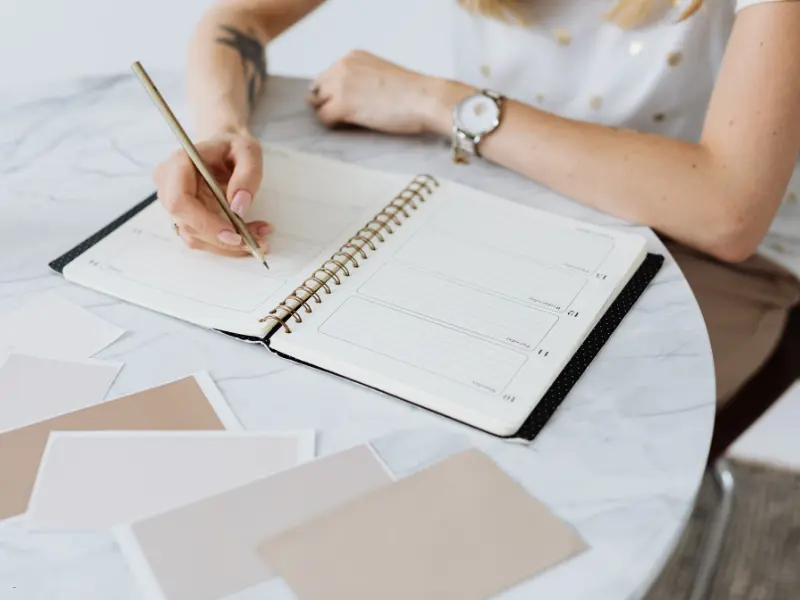 Self-hosted scheduling platform concept shown with a planner and design swatches on a marble table